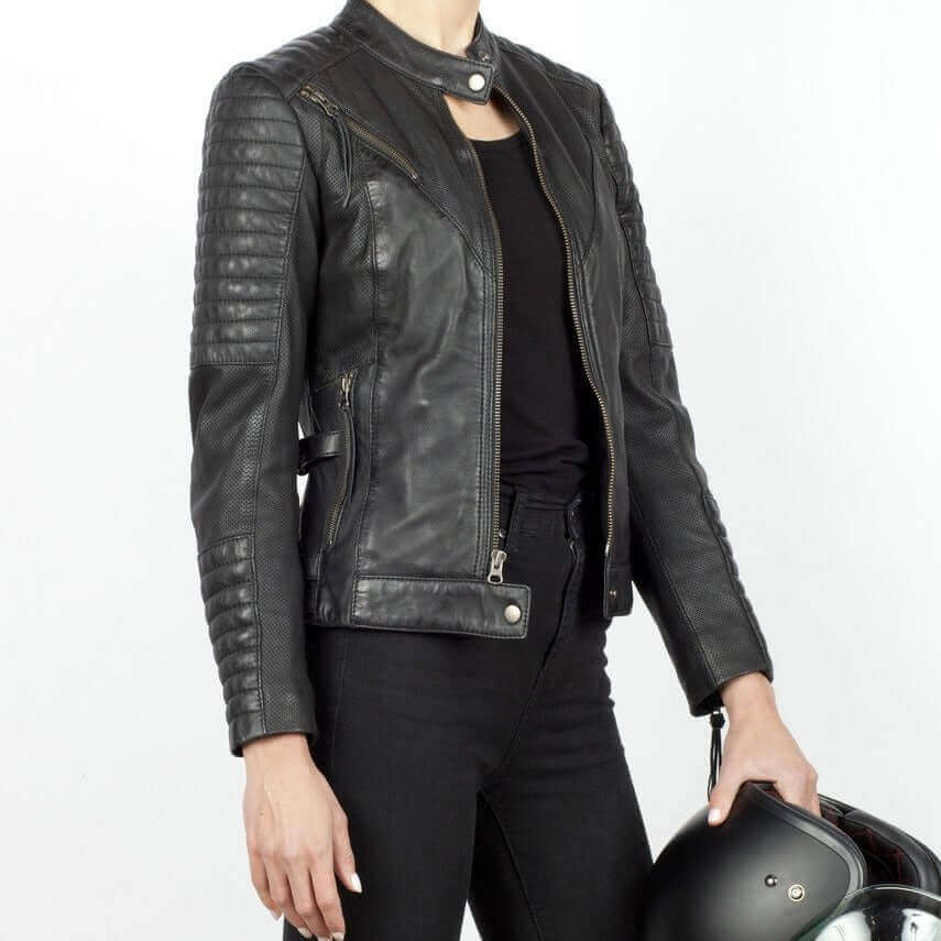 A woman holding a helmet wearing a black Wild and Free leather jacket unzipped