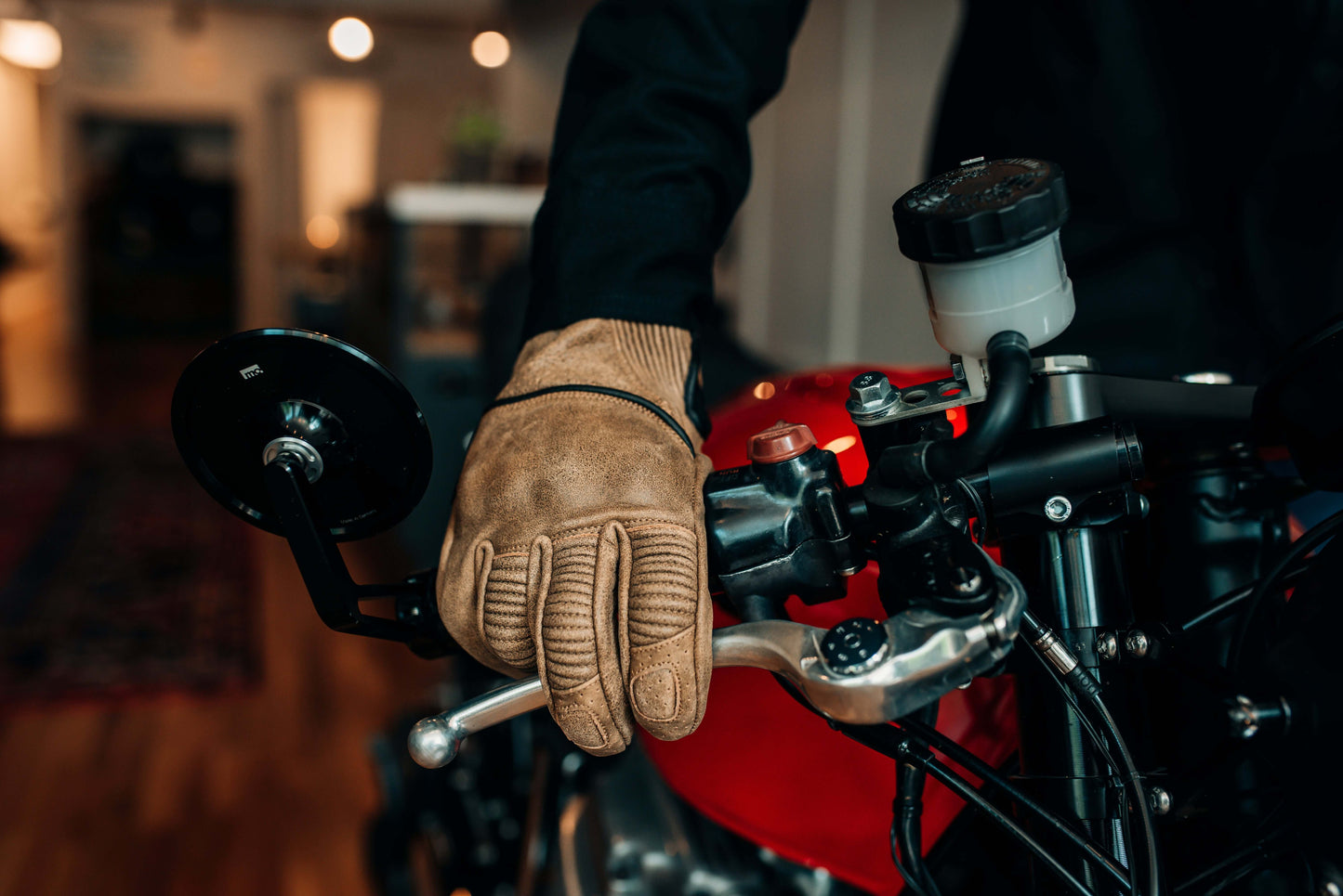 Torc Escondido tan motorcycle gloves on motorcycle brake lever worn by Sully's Ride Shop employee