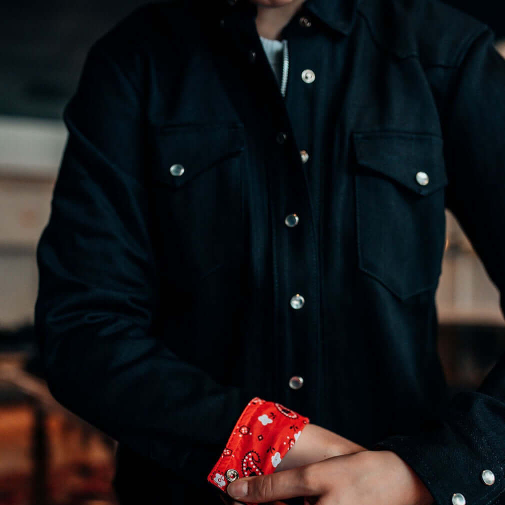 A model showing the red bandana cuff of a Riveter Riding Shirt