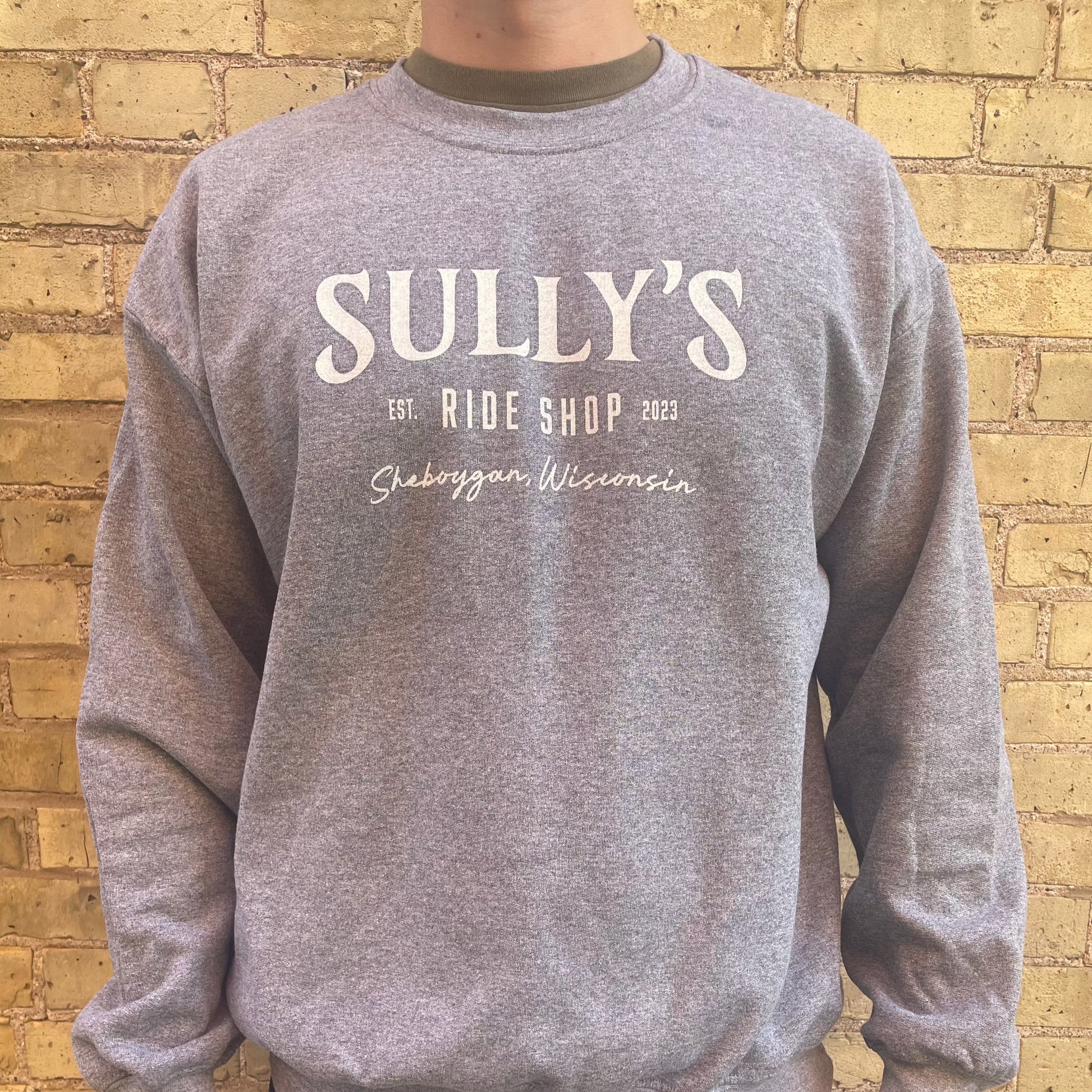 Sully's Sheboygan Crew Neck Sweatshirt on male model in with city brick background