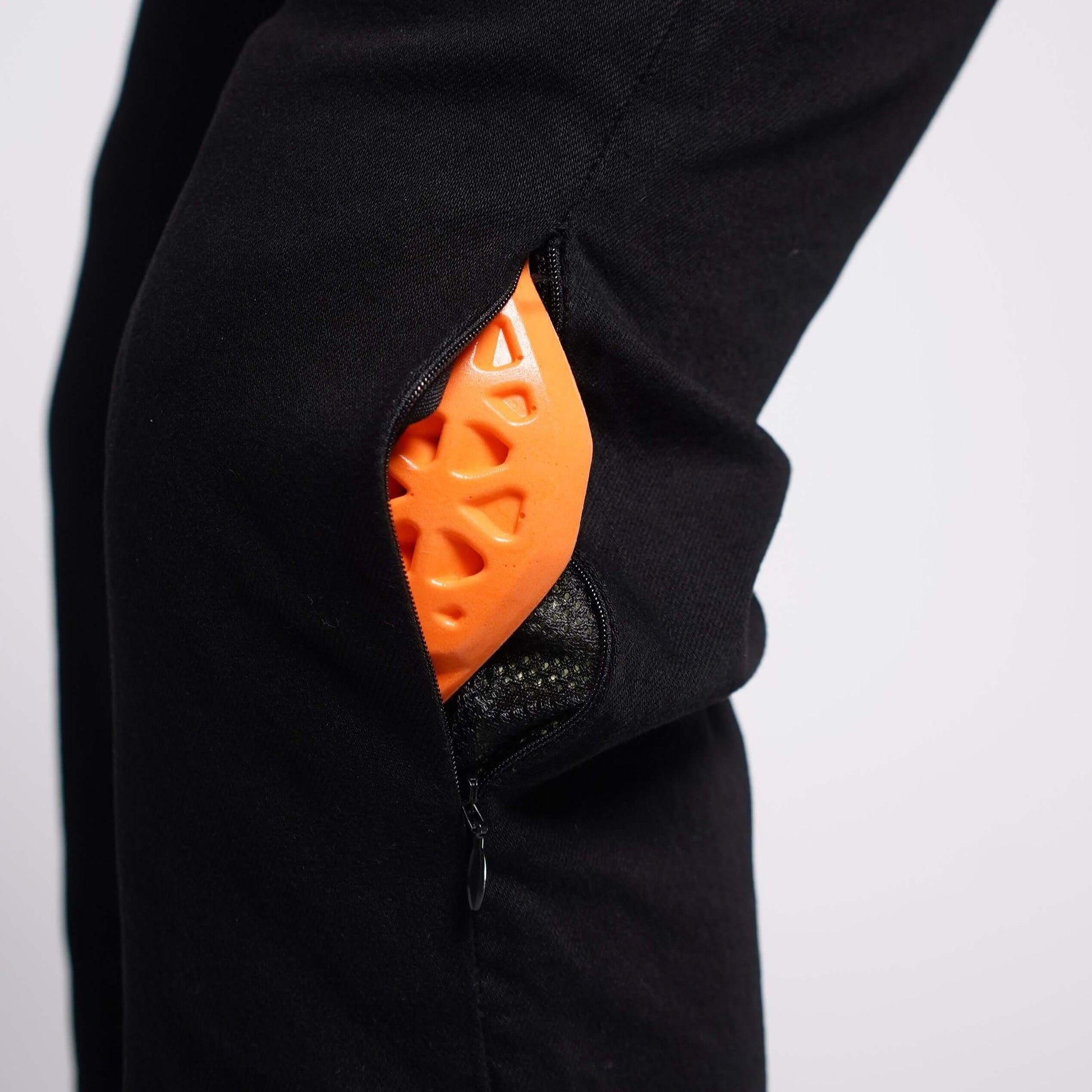 A side view of the unzipped knee pocket with orange armor slightly showing on Boondocks overalls