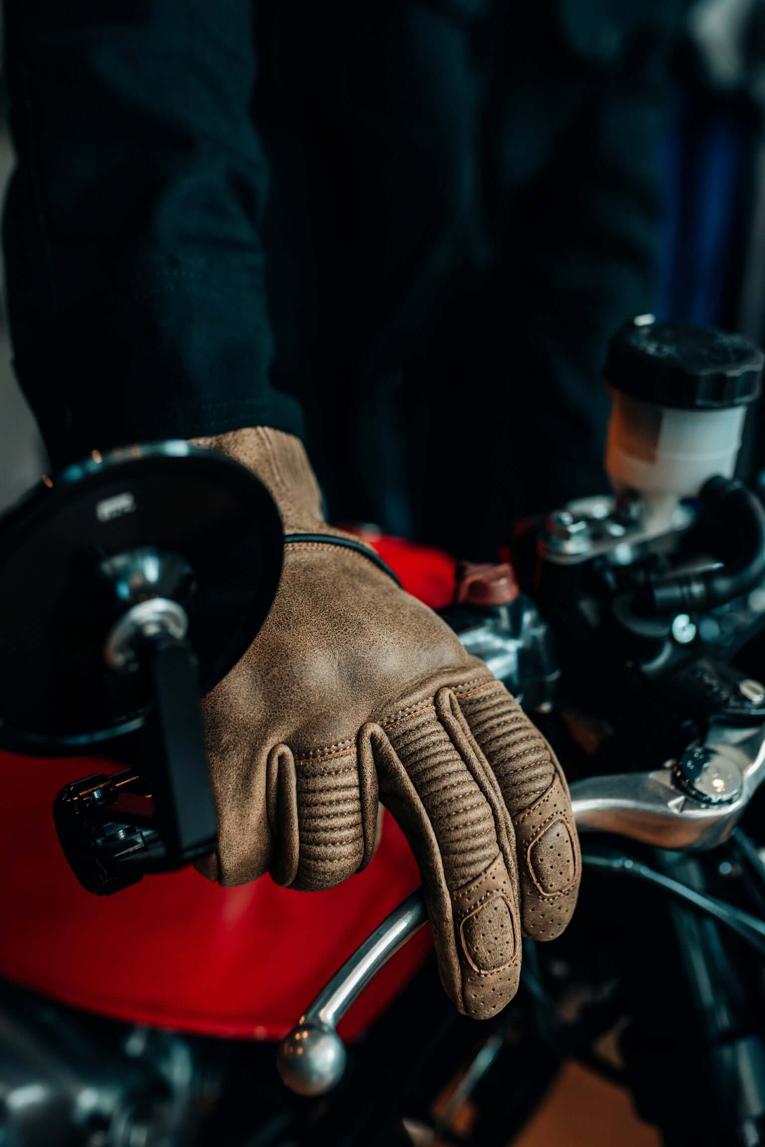 Torc Escondido tan motorcycle gloves on motorcycle brake lever worn by Sully's Ride Shop employee side